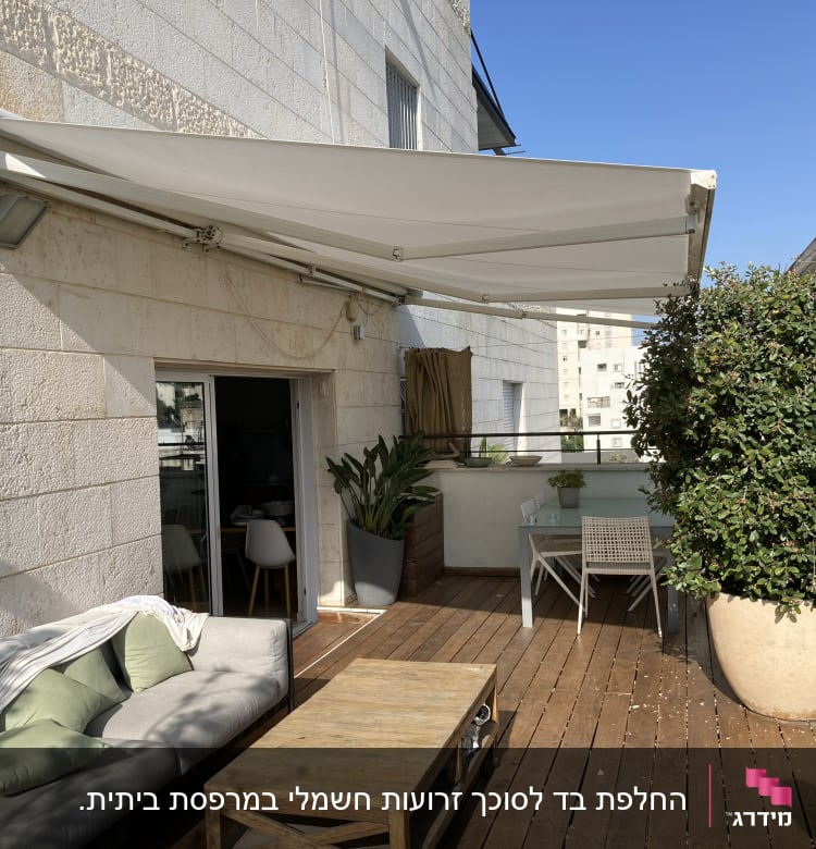 סוכך לבן פתוח על מרפסת עץ עם צל חלקי